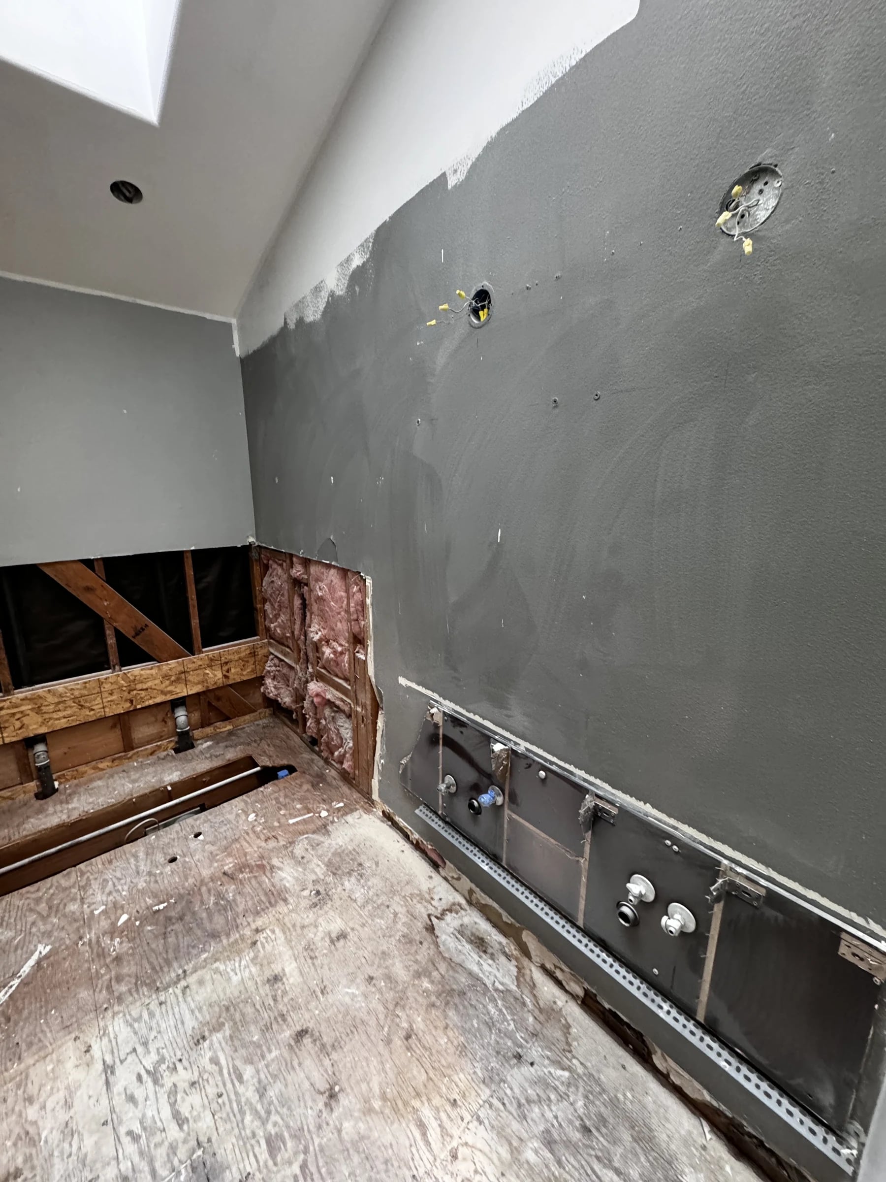 Bathroom in Pacific Palisades before: stripped to studs and subfloor under a skylight
