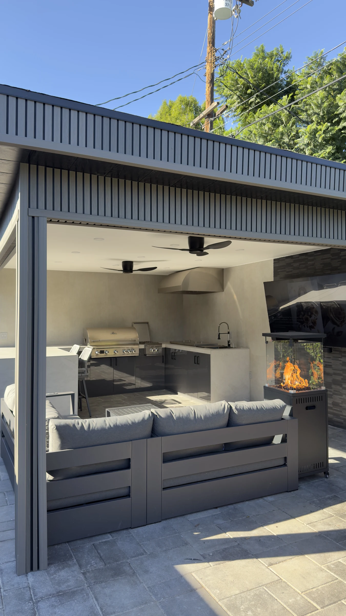 Covered outdoor pavilion with lounge seating and a fire table in Laguna Beach