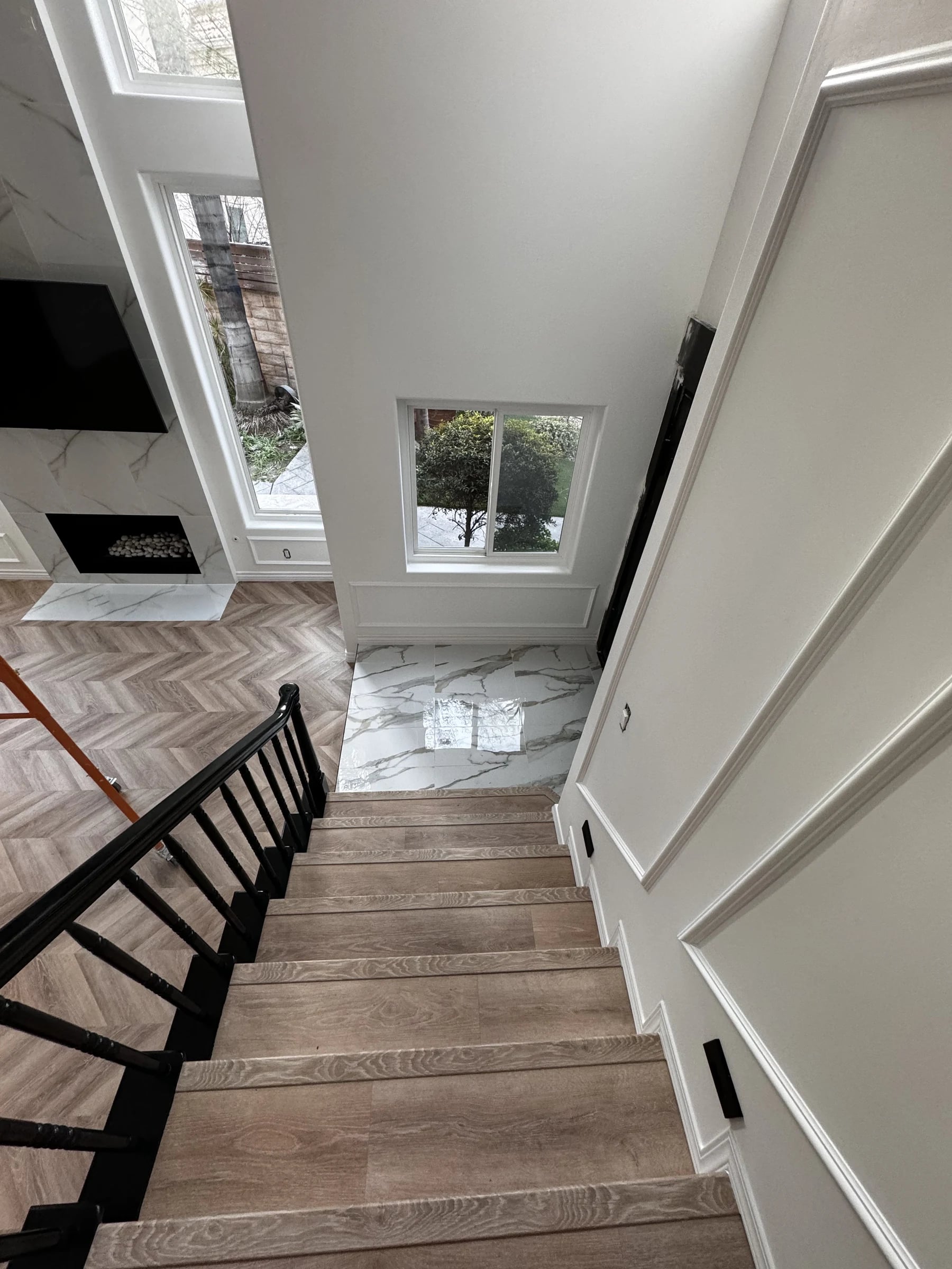 Staircase overlooking a herringbone wood floor in San Marino