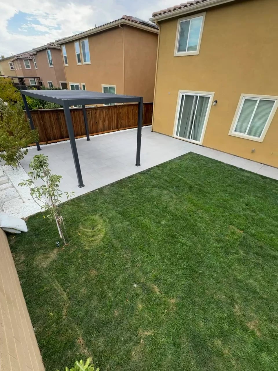 Same backyard in Mission Viejo after: tile patio, steel pergola and new lawn